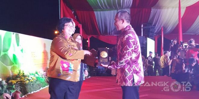 Kepala Dinas Kebersihan dan Pertamanan Kota Malang, Erik Setyo Santoso menerima penghargaan plakat adipura dari menteri lingkungan hidup dan kehutanan di Siak, Riau