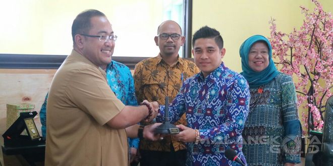Kadis Kominfo Kota Malang Zulkifli Amrizal menerima cendera mata dari perwakilan Komisi I DPRD Kota Bukittinggi