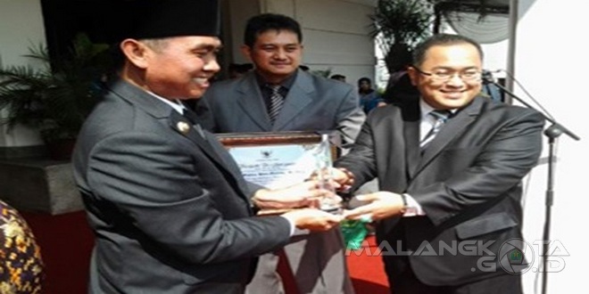 Kepala Dinas Kominfo Kota Malang Zulkifli Amrizal ( kanan) menyerahkan penghargaan yang diraih FK Meta Bagra kepada Walikota Malang H. Moch. Anton