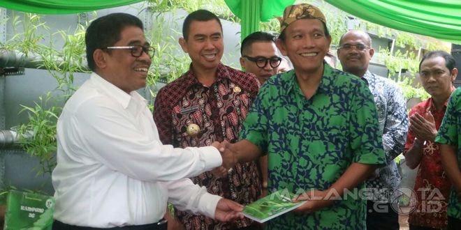 Penggagas Kampung 3G Bambang Irianto (kanan) memberikan buku tentang Go Green kepada Dirjen Otonomi Daerah Kemendagri Sumarsono